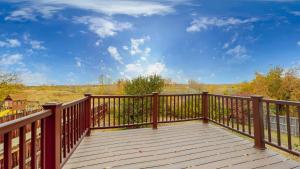 a balcony with a wooden railing and a blue sky at Comfortable Family Friendly Home on Quincy Reservoir in Aurora