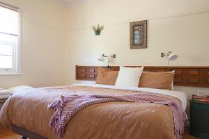 Un dormitorio con una cama grande y dos lámparas. en Spring Creek Cottage Hepburn - Secluded Pet Haven, en Hepburn Springs