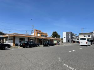 une rue avec des voitures garées devant un bâtiment dans l'établissement CORNER SHOP Miyota, à Miyota