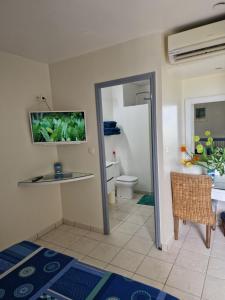 拉特里尼泰appartement spacieux vue sur mer的一间带卫生间的浴室和墙上的电视