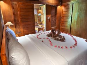 a cake with two chocolatecovered hearts on a bed at The Kori Sire in Tanjung