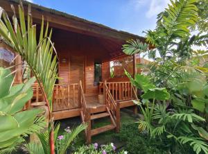 a wooden cabin with a porch in a garden at The Kori Sire in Tanjung +61 photos