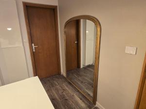 a mirror in a room with a wooden door at Studio de standing en hyper centre in Strasbourg