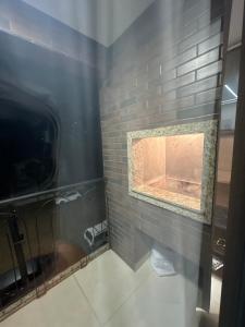 a bathroom with a brick fireplace in a room at Apartamento Alto padrão in Caràzinho