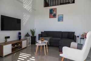 a living room with a couch and a tv at Anna Maria's Maisonette II in Kardamaina
