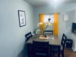 a dining room table with chairs and a vase of flowers at Gem in Da Pearl in Topsail