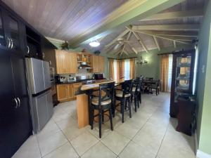 Una cocina con mesa y sillas y un refrigerador. en Luxury Spacious Villa with Aircon and Pool Table, en Olveston