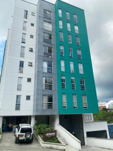 a building with a car parked in front of it at Apartamento Urban Manizales in Manizales