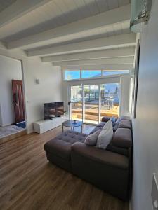 Una sala de estar con un sofá y una ventana grande. en Cygnets, en Lake Munmorah