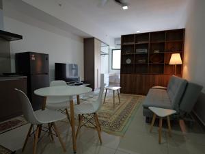 シャー・アラムにあるAlinea Apartment, Shah Alamのソファとテーブルと椅子のあるリビングルーム