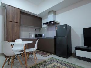 シャー・アラムにあるAlinea Apartment, Shah Alamのテーブルと椅子と冷蔵庫のあるキッチン +1枚の写真