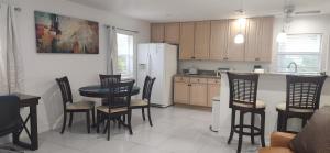 a kitchen with a table and chairs and a refrigerator at Seagate Cottage in Naples