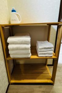 a shelf with folded towels on it in a bathroom at 呉house in Ishigaki Island +14 photos