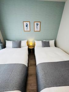 two beds in a room with a table between them at 呉house in Ishigaki Island