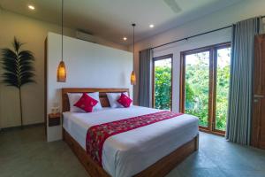 a bedroom with a large bed with red pillows at Segara Gunung 3 Bedrooms Luxury Villa with Breathtaking Sea View in Temukus +46 photos
