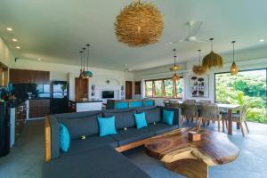 a living room with a blue couch and a table at Segara Gunung 3 Bedrooms Luxury Villa with Breathtaking Sea View in Temukus