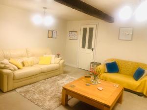 a living room with a couch and a coffee table at Tilly Cottage - overlooking Pendle Hill in Barrowford +36 photos