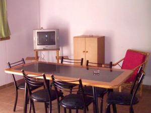 a dining room table with chairs and a tv at La Matilde in Villa Ciudad de America