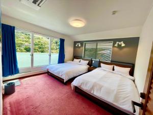 a bedroom with two beds and a large window at Sunset Villa Shirahama 5 min to the beach Pets OK in Shimoda