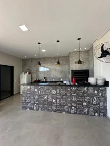 a kitchen with a counter with a wall with drawings on it at LAR Espaço Lazer in Foz do Iguaçu