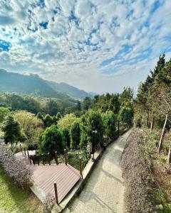 a walkway with benches and trees on a hill at Artistic Forest in Lung-yen +30 photos