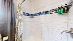 a white tiled shower with a shower curtain at Peaceful retreat in quite neighborhood in Denver