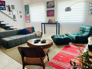 een woonkamer met een bank en een tafel bij Descubra a Casa Felicidade em Belém! Climatizada, com sala ampla, 2 quartos, mezanino e Wi-Fi veloz. Localização central perto de atrações e gastronomia. Viva a Amazônia com conforto exclusivo. Reserve já sua experiência inesquecível! in Curro Velho +26 foto's