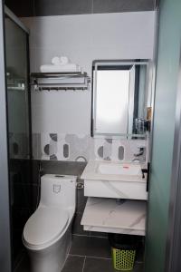 a bathroom with a toilet and a sink and a mirror at Suka Hotel in Tây Ninh