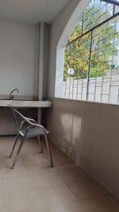 ein Stuhl steht in einem Zimmer mit Fenster in der Unterkunft Convenient Resort in Lat Krabang + 135 Fotos