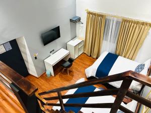 a room with a bed and a desk and a television at Casa Nueva ACCEL Hotel in Ibarra