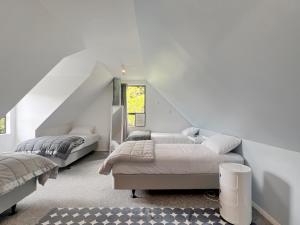 a white bedroom with two beds and a window at 6 Beds 2 Bathrooms Private Holiday Home in Akaroa