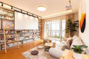 a living room with a white couch and a projection screen at Book and Bed-People's Square in Shanghai +284 photos