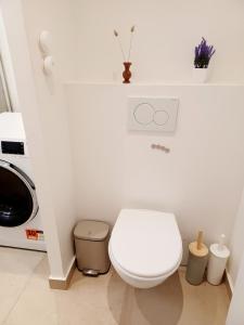 Un baño blanco con inodoro y microondas. en 2 beds, modern building, with mobile AC, Paris Expo, 7' metro 2 steps to Paris, en Montrouge 6 fotos más
