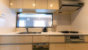 a small kitchen with a sink and a microwave at Homey Inn in Kyoto