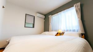 two beds in a bedroom with a window at Homey Inn Kujo Kawaramachi in Kyoto +31 photos