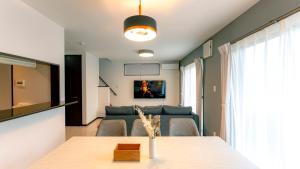 a living room with a table and a couch at Homey Inn Kujo Kawaramachi in Kyoto