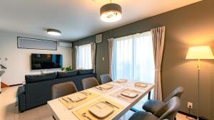 a living room with a table and a couch at Homey Inn Kujo Kawaramachi in Kyoto