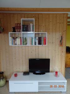 a room with a desk with a tv and books at Neumühleweg 19 in Lauperswil
