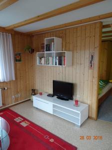 ein Wohnzimmer mit einem Flachbild-TV auf einem Tisch in der Unterkunft Neumühleweg 19 in Lauperswil