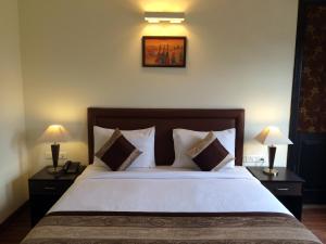 a bedroom with a large bed with two lamps on tables at La Residence in Gurgaon