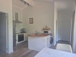 a white kitchen with a sink and a microwave at Retreat in Stirling in Stirling +9 photos