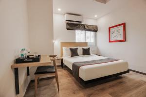 a hotel room with a bed and a desk and a bed sidx sidx sidx sidx at Townhouse 359 Begumpet Near Hyderabad Central in Hyderabad +53 photos