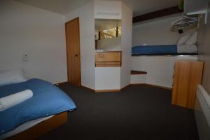 - une chambre avec 2 lits, un lavabo et un miroir dans l'établissement Moonbah Ski Lodge, à Thredbo