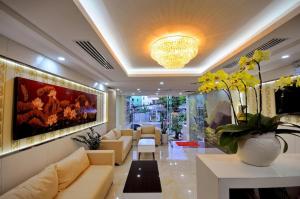 a living room with couches and a painting on the wall at Yellow Sea Hotel Nha Trang in Nha Trang