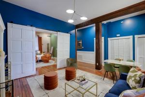 a living room with blue walls and a table and chairs at Mid-Century getaway in Savannah