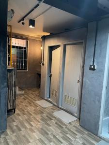 an empty room with two doors and a tile floor at Brio Cafe and Hostel in Godown +72 photos