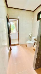 ein Badezimmer mit Toilette und Fenster in der Unterkunft Villa Dua - Beachfront Sunset Garden Villa in Nathon Bay