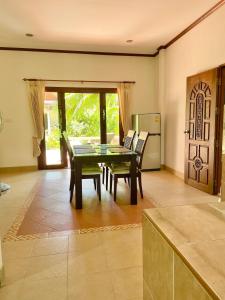 ein Esszimmer mit Tisch und Stühlen und eine Küche in der Unterkunft Villa Dua - Beachfront Sunset Garden Villa in Nathon Bay + 33 Fotos