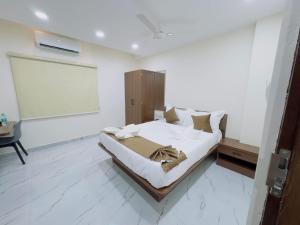 a bedroom with a bed and a white wall at Hotel Apex Inn Hyderabad Airport in Hyderabad +13 photos