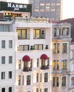 a tall white building with red awnings on it at Maroon Hotel Pera in Istanbul